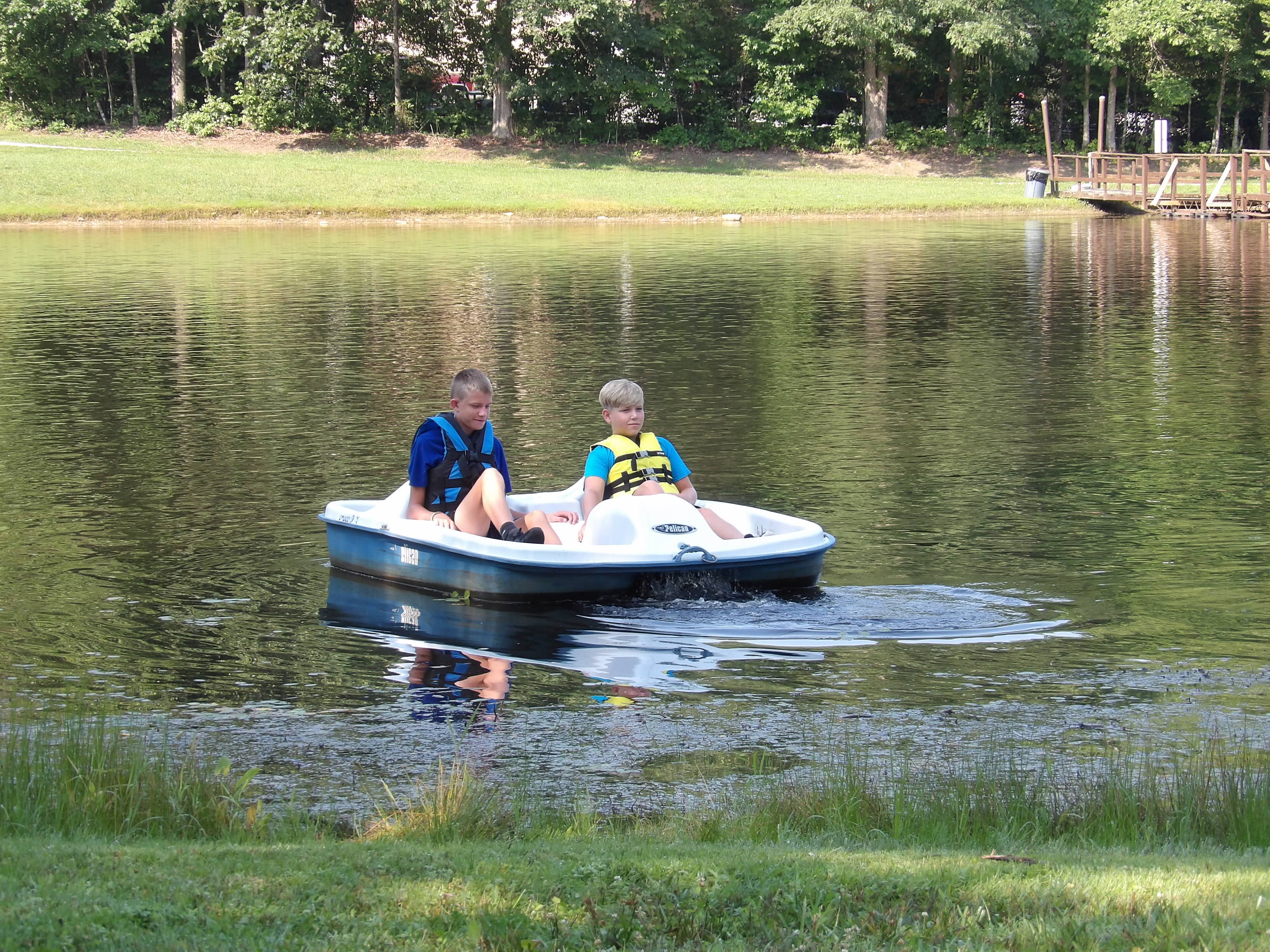 Two boys in a paddle boat on the lake at camp J.M. Feltner.